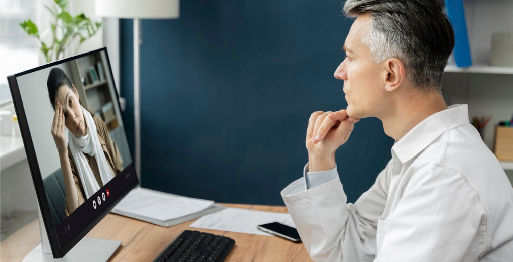 Doctor on a virtual telehealth call with a patient via laptop.